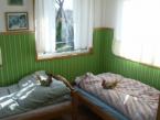 Sypialnia wna werandzie domku, pozotae miejsca do spania na maym poddaszu.